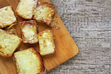 Bir kesme tahtası ahşap kurullarında üzerinde erimiş peynirli tost