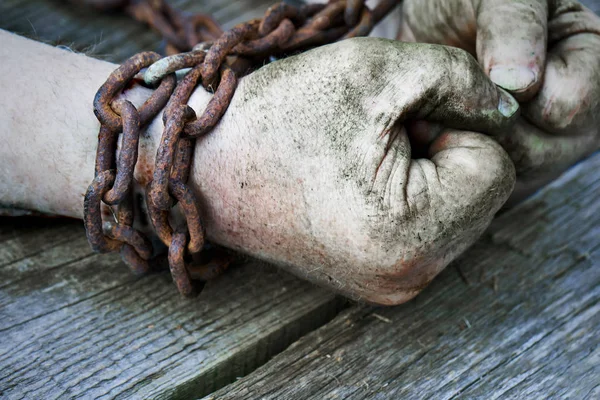 Poderosas manos masculinas sucias apretadas en puños encadenados con cadena oxidada . —  Fotos de Stock
