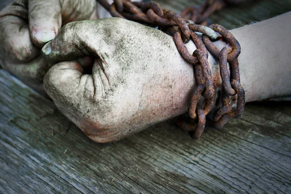 Poderosas manos masculinas sucias apretadas en puños encadenados con cadena oxidada . — Foto de Stock