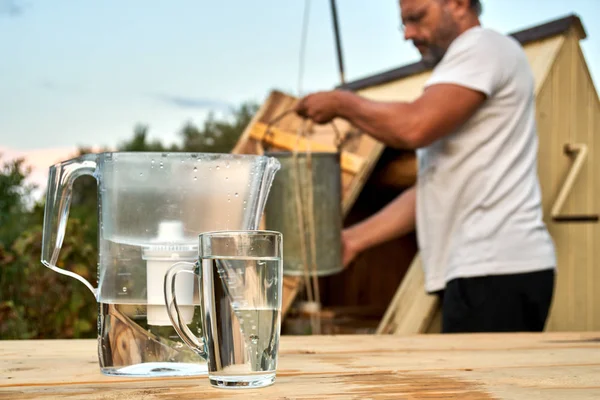 Waterzuivering met behulp van een filter Waterkaraf op het platteland in de zomer — Stockfoto