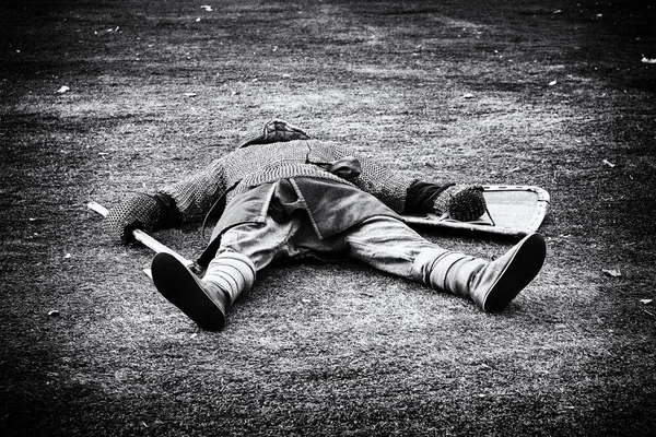 Defeated medieval warrior lying dead on the green grass — Stock Photo, Image
