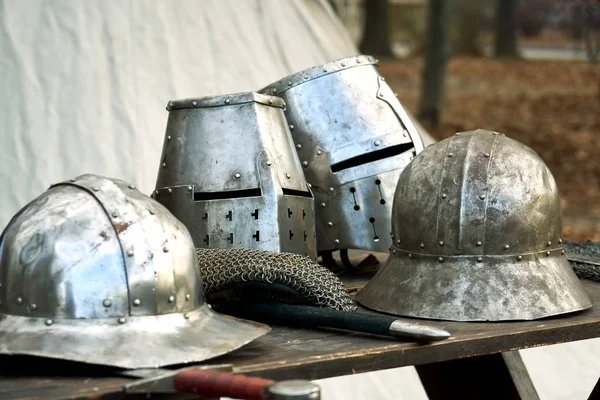 Mittelalterliche Helme mit Augenschlitzen stehen auf dem Tisch — Stockfoto