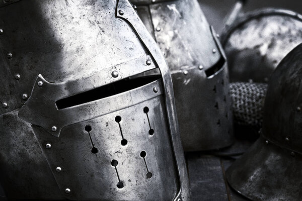 Side view of the steel medieval helmets with eyes slits. Black and white photograph