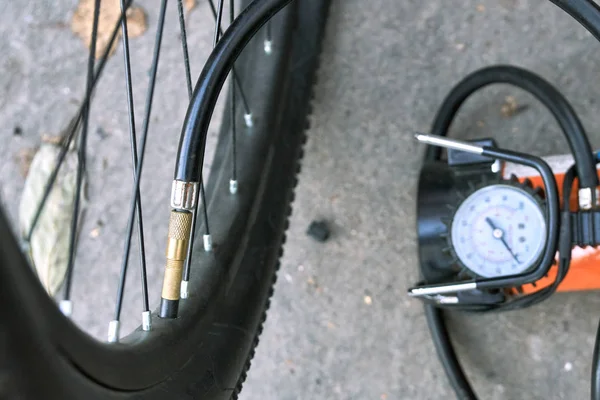 Pumping up a bicycle tire using an electric air car compressor outdoors