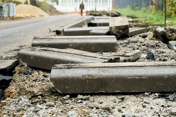 Złamane świeżo wykopane starych krawężników z kawałkami asfaltu i ziemi leżącej na drodze w Moskwie. — Zdjęcie stockowe