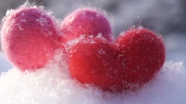 Sevgililer günü kavramı. İki yün oyuncak kar üzerinde hearts ve kış sabah güneş tarafından backlighted. Ağır çekim
