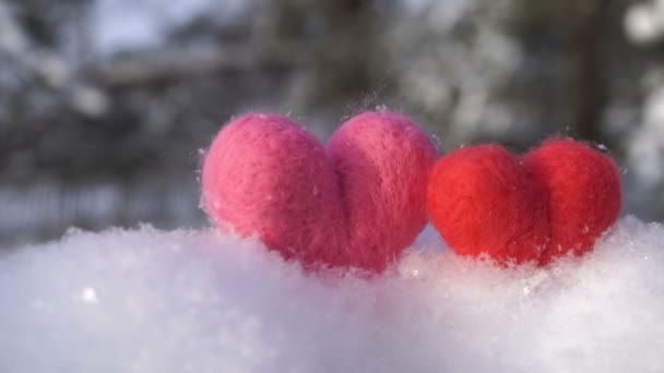 Dois corações de lã de Valentim na neve branca clara no inverno câmera lenta — Vídeo de Stock