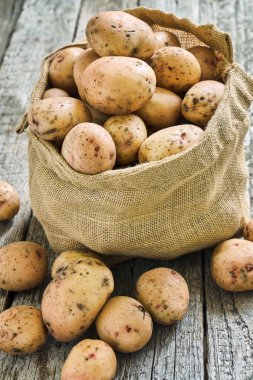 Bir çuvala kaba ahşap kurullarında ham patates