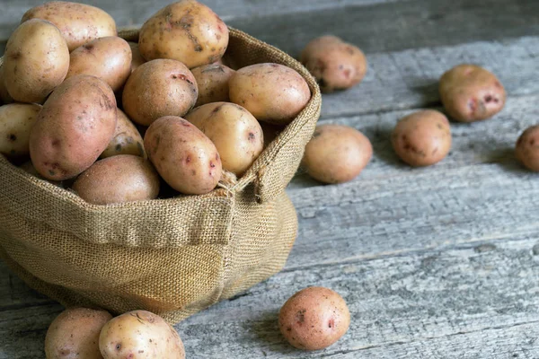 Raw Unpeeled Potatoes Burlap Sack Close Standing Rough Wooden Boards — Stock Photo, Image