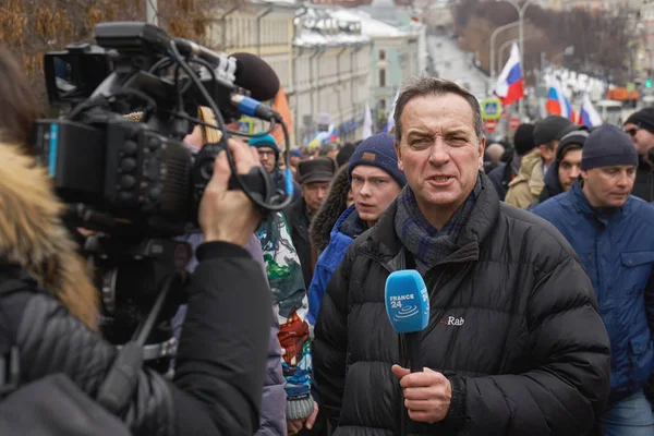 Памятный марш Немцова. С места происшествия ведет репортаж иностранный журналист с микрофона — стоковое фото