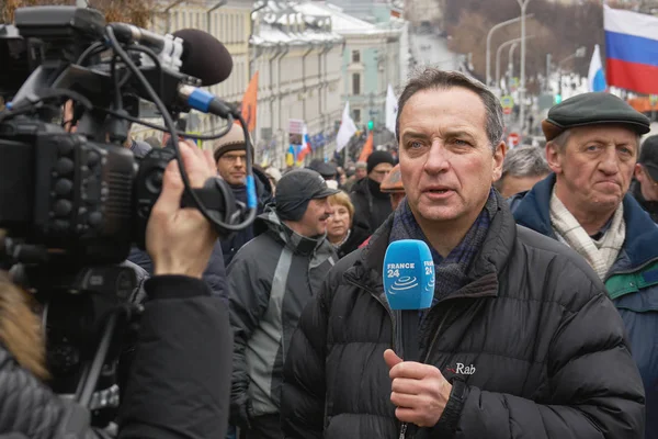 Памятный марш Немцова. С места происшествия ведет репортаж иностранный журналист с микрофона — стоковое фото