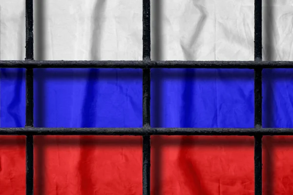 Bandeira russa atrás de barras de prisão de metal preto com sombras — Fotografia de Stock