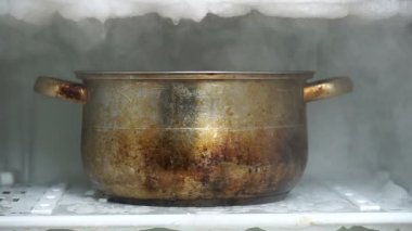 Sıcak su dolu büyük bir mutfak tencere kullanarak bir buzdolabı defrosting