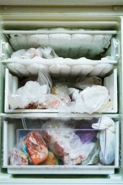 Uzun zamandır çözülmüş olmayan bir dondurucu lu açık buzdolabı ve bol miktarda dondurulmuş buz