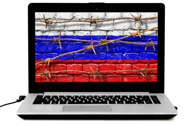 Laptop isolado com arame farpado enferrujado e bandeira russa pintada em uma parede de tijolo na tela — Fotografia de Stock