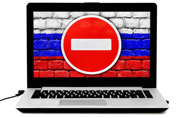 Ноутбук с дорожным знаком "НЕ Входите" и российским флагом, нарисованным на кирпичной стене на экране — стоковое фото