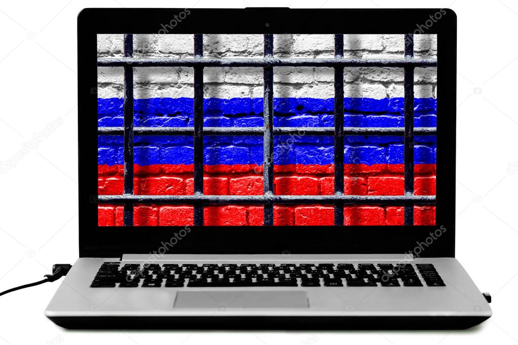 Isolated laptop with prison bars and Russian flag painted on a brick wall on the screen