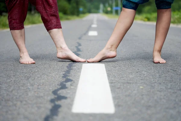 一个成年妇女和一个年轻女孩在沥青路上赤脚的腿 — 图库照片