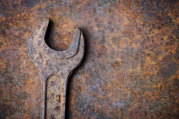 Старый ржавый гаечный ключ на металлическом фоне — стоковое фото