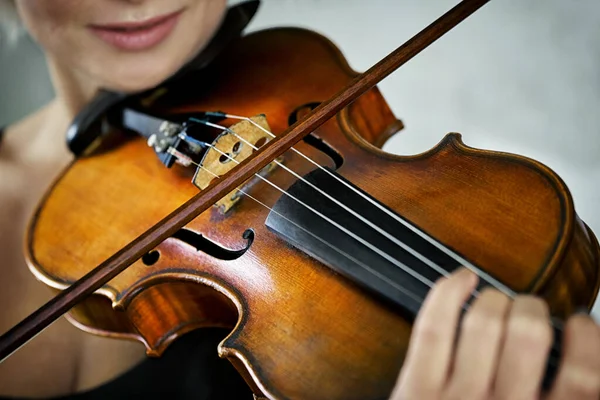 Violin and a fiddlestick in hands of a young female violinist — Stock Photo, Image