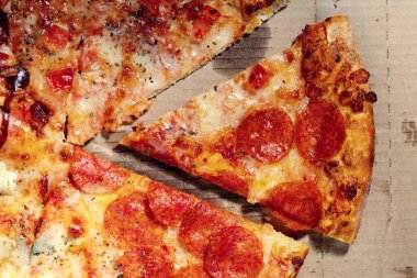 Açık teslimat kutusunun kartonunda kırmızı sosisli lezzetli bir pizza.