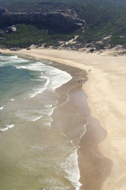 Güneşli bir günde güzel kumlu bir sahilden manzarayı seyret.