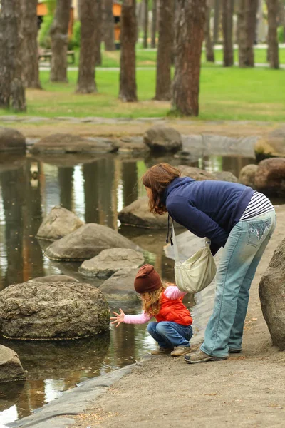 Mamá Sosteniendo Niña Pequeña Comprobando Agua Estanque Del Parque Primavera —  Fotos de Stock