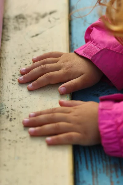 Närbild Småbarn Flicka Händer Rosa Jacka Gamla Färgglada Träbänk — Stockfoto