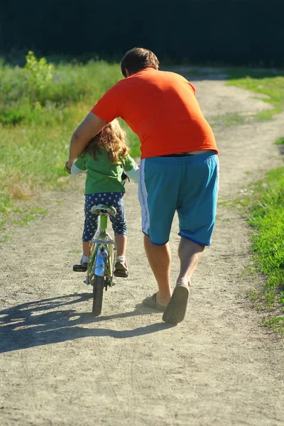 Padre Enseñando Hija Andar Bicicleta Una Carretera Polvorienta Vista Trasera —  Fotos de Stock