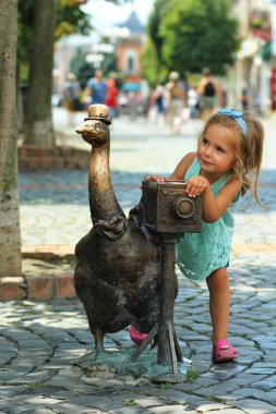 Mukachevo, Ukraine - August 6, 2018: Monument of a goose with a retro camera installed on the city central square on St. Martin's Day - the day of the city. (Goose is the symbol of the city) clipart