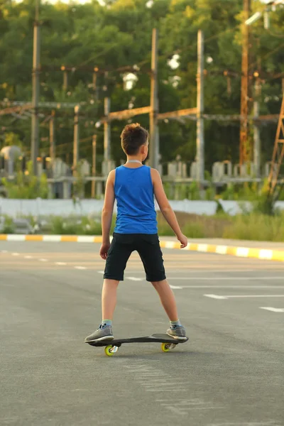 Junge Fährt Skateboard Auf Sommerparkplatz Der Nähe Des Kraftwerks Rückansicht — Stockfoto