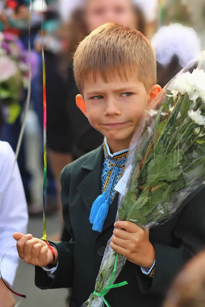 Funny first year student with flower bouquet at his first school day.