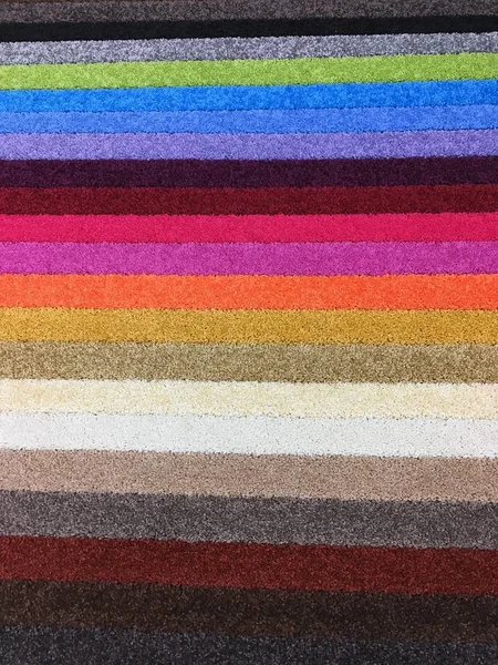 Layers of colorful carpet floor covering, vertical background