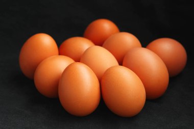 Brown chicken eggs isolated on black background, selective focus