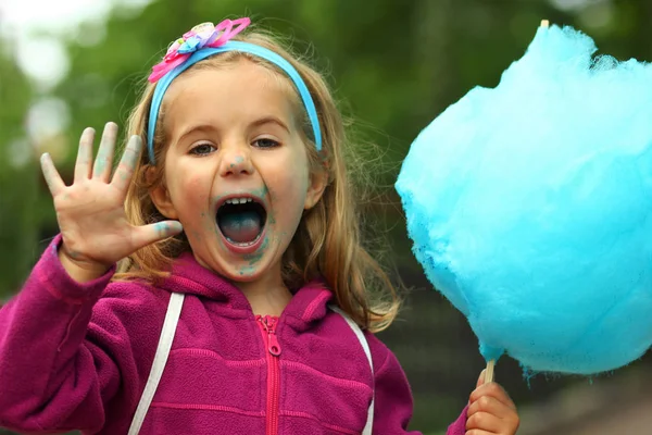明るい青い綿菓子を食べる幸せな幼児の女の子のクローズアップ肖像画 — ストック写真