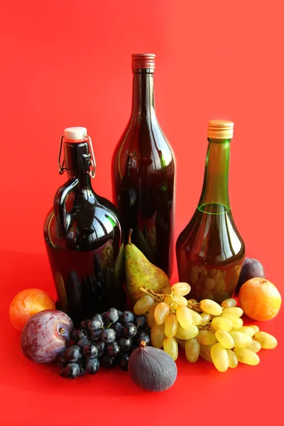 Φθινόπωρο Νεκρή Φύση Μπουκάλια Κρασιού Και Φρούτα Πάνω Από Κόκκινο — Φωτογραφία Αρχείου