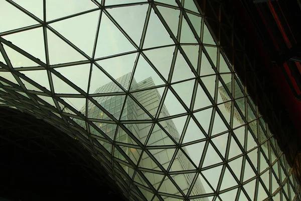 Sky and skyscrapers through glass ceiling. Modern architecture abstract background