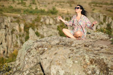 35 yaşında, beyaz bir kadın Ukrayna 'nın Aktove Kanyonu uçurumunda meditasyon yapıyor.