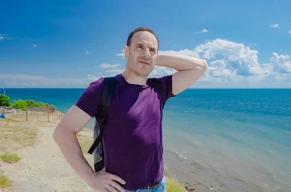 Un homme plus âgé souriant avec une main derrière la tête se tient sur le fond de la mer . — Photo