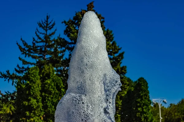 Jets de fontaine sur un fond d'arbres — Photo