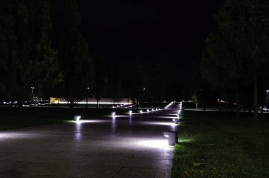 Parkta fenerlerle aydınlatılan yürüyüş yolu. Krasnodar Parkı.