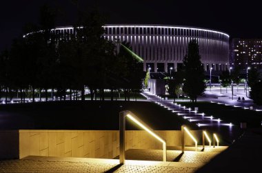 Stadyuma bakan fenerler ile aydınlatılmış parkta yürüyüş yolu. Krasnodar Parkı.