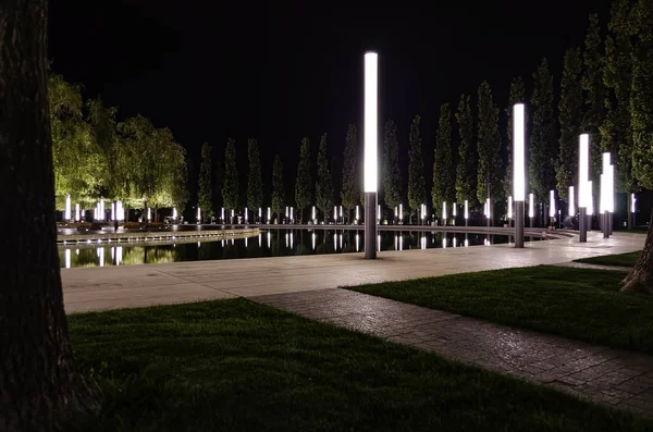 Árvores simetricamente arranjadas com lanternas ao longo da fonte no Parque de Krasnodar . — Fotografia de Stock
