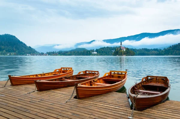Båtar på sjön Bled i Slovenien. Fjällsjö med liten ö, och kyrkan. — Stockfoto