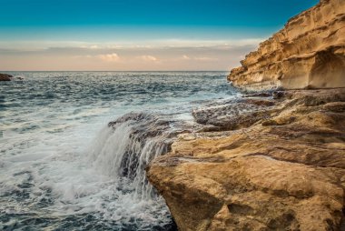 Kaya karşı dalgalar çarpışma su cascade oluşturma St. Peters Pool Near Marsaxlokk, Malta