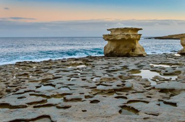 Rock formations at St. Peters Pool at sunset near Marsaxlokk, Malta.