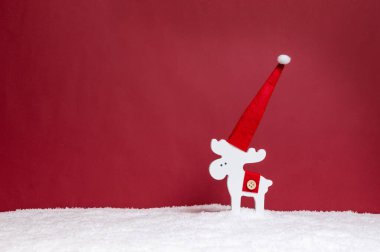Noel Baba 'nın beyaz geyikleriyle minimalist Noel tatili konsepti kırmızı arka planda fotokopi alanı ile karşılaşıyor