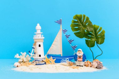 Oyuncak yelkenli, kumlu adanın kaptanı deniz feneri, canavar palmiyesi, mercan, deniz kabuğu ve mesaj şişesi olan.