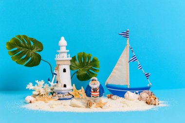 Oyuncak yelkenli, kumlu adanın kaptanı deniz feneri, canavar palmiyesi, mercan, deniz kabuğu ve mesaj şişesi olan.