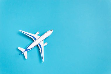 Mavi arka planda beyaz uçak ve metin için kopyalama alanı. Asgari seyahat kavramı